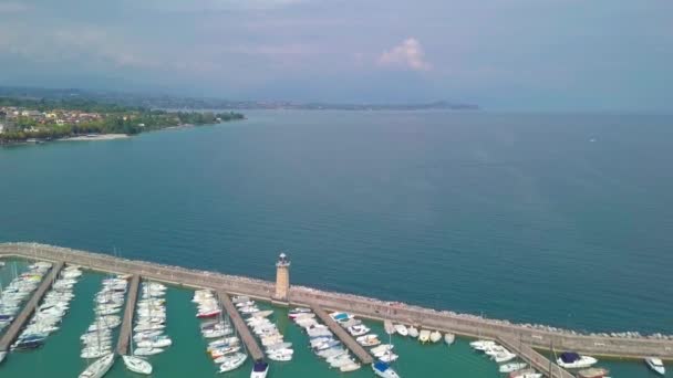 Havadan görünümü tekneleri ve Lake Garda, İtalya kıyıları. Tekneler ve kıyı Lago di Garda üzerinde yaz tatil üzerinde uçan. — Stok video