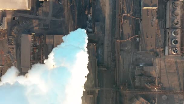 La zone industrielle avec un grand tuyau rouge et blanc épaisse fumée blanche est versée du tuyau d'usine contrairement au soleil. Pollution de l'environnement : une pipe à fumée. Vue aérienne — Video