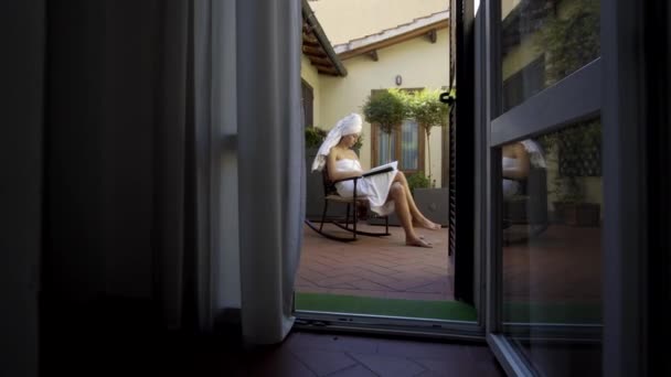 Mulher bonita ler revista por mesa em casa — Vídeo de Stock