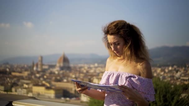 Молодая девушка смотрит на карту города. Привлекательная девушка в исследовании нового места. 4K . — стоковое видео
