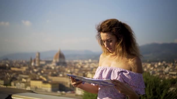 Chica joven mirando en el mapa de la ciudad. Chica atractiva en explorar un nuevo lugar. 4K . — Vídeos de Stock