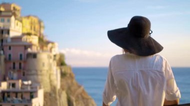 Şapkalı kız Manarola şehir İtalya arka plan üzerinde duruyor