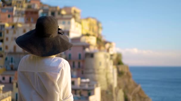 Menina de chapéu fica no fundo da cidade de Manarola Itália — Vídeo de Stock