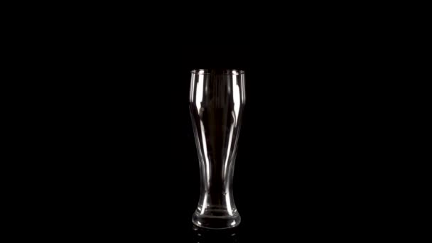 Vaso de cerveza vacío gira sobre un fondo negro — Vídeos de Stock