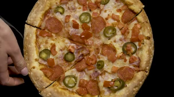 Mão leva uma fatia de pizza em um fundo preto — Vídeo de Stock