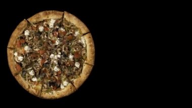Tütsülenmiş sosis ve zeytin siyah bir zemin üzerine dönen pizza. Üstten görünüm merkezi yönlendirme