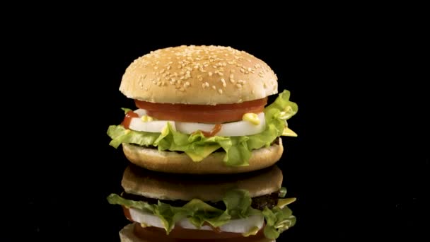 Rotación de deliciosa hamburguesa sobre fondo negro . — Vídeos de Stock