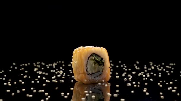 Rollo de sushi con salmón y caviar sobre fondo negro giratorio . — Vídeo de stock