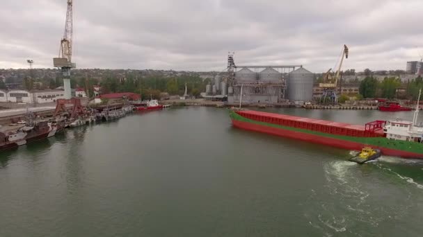 Большой корабль и одна буксировочная лодка в морском порту — стоковое видео