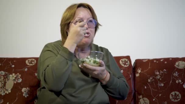 Ηλικία γυναίκας τρώει salat λαχανικών στο σπίτι — Αρχείο Βίντεο