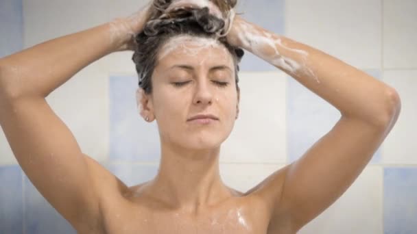 Милая забавная женщина под душем, моющая длинные волосы — стоковое видео