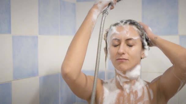 Mulher engraçada bonito sob o chuveiro lavar cabelos longos — Vídeo de Stock