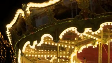 Büyüleyici yanıp sönen ışıkları karanlık gece gökyüzü Aydınlatma Fuarı atlıkarınca dönme dolap karnavalında yuvarlak vintage merry go