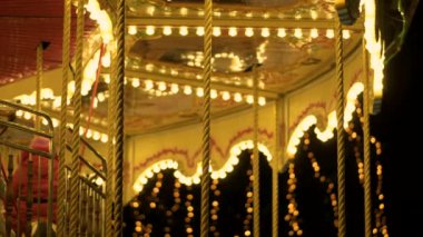 Büyüleyici yanıp sönen ışıkları karanlık gece gökyüzü Aydınlatma Fuarı atlıkarınca dönme dolap karnavalında yuvarlak vintage merry go