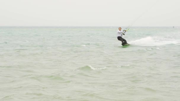 Businessman rides a kite in the tropical ocean and performs tricks — Stock Video