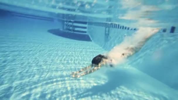 La joven se zambulle en la piscina, en cámara lenta bajo el agua — Vídeo de stock