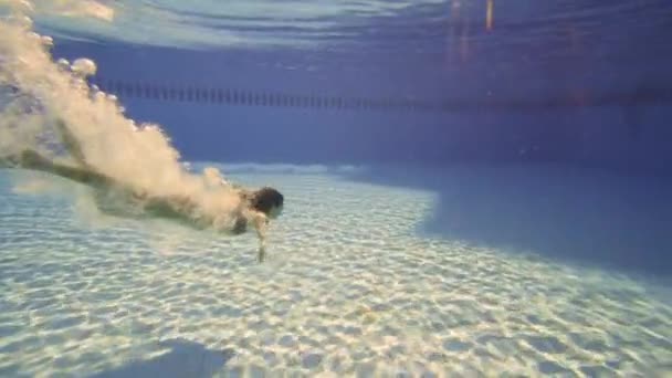 La Mujer en el Bikini nadando bajo el agua con las llamaradas hermosas del sol en cámara lenta . — Vídeo de stock