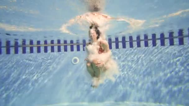 La ragazza che salta nella piscina blu profondo — Video Stock