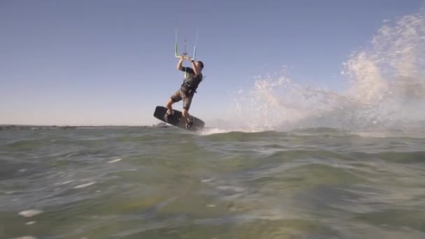 Kitesurfer salta y salpicadura de agua entra en la cámara — Vídeos de Stock