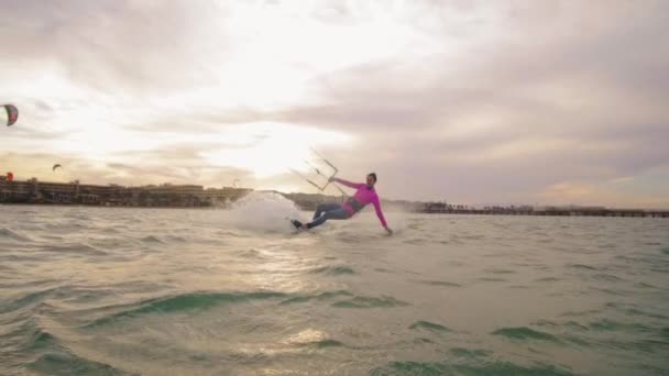 Gyönyörű fiatal nő kiteboarding napnyugtakor a lassú mozgás, aktív életmód extrém sport — Stock videók