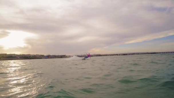 Bonita jovem kiteboarding ao pôr do sol em câmera lenta, estilo de vida ativo esporte extremo — Vídeo de Stock
