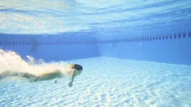 Привлекательная женщина плавает в бассейне в замедленной съемке — стоковое видео
