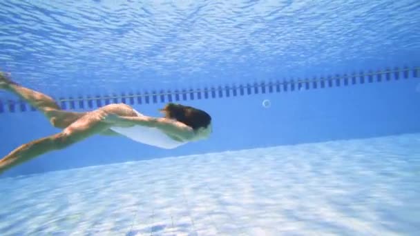 Mujer sexy en bikini blanco buceando en la piscina en un día soleado — Vídeos de Stock