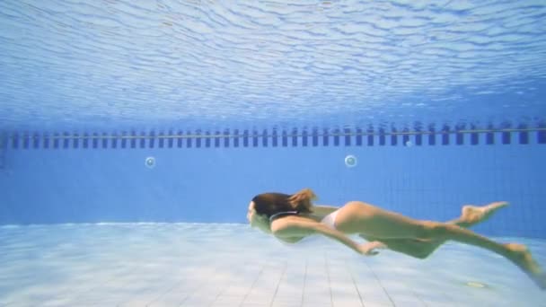 Mulher sexy em biquíni branco mergulhando na piscina em um dia ensolarado — Vídeo de Stock