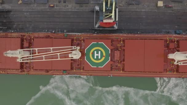 Luchtfoto 4k Uhd beeldmateriaal lading vracht schip met werkende kraan brug in scheepswerf voor logistieke Import Export achtergrond, bovenaanzicht — Stockvideo