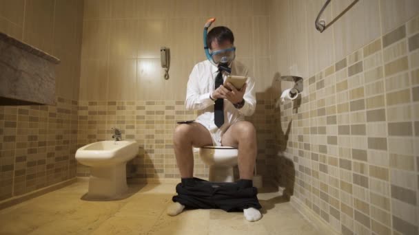 Бизнесмен в водолазной маске работает в туалете — стоковое видео