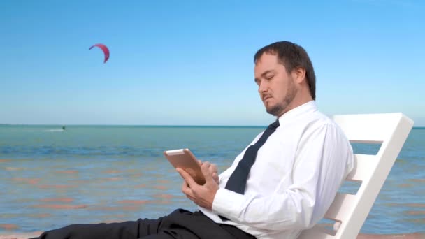 Young businessman is working on the laptop on the beach. — Stock Video