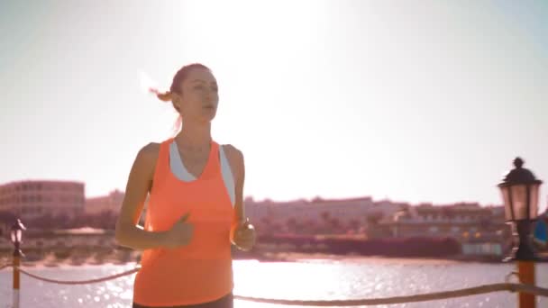 Mladá žena, běhání v západu slunce, pomalý pohyb — Stock video