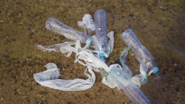 Contaminación plástica en el problema ambiental oceánico. Vasos de plástico, bolsas de transporte, botellas y pajitas vertidas en el mar — Vídeos de Stock