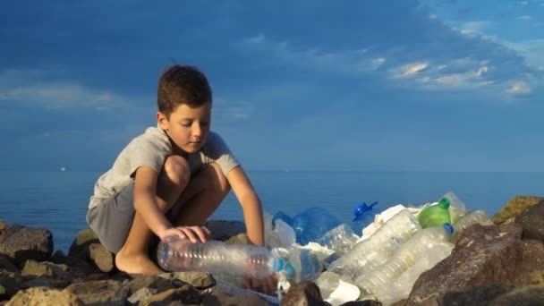 Niño voluntario limpiando la playa en el océano. Concepto de ecología segura . — Vídeos de Stock