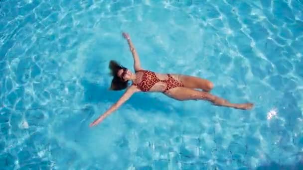 Vista desde arriba, hermosa joven flotando en aguas cristalinas — Vídeos de Stock