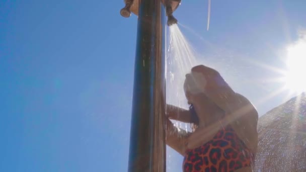 Happy young woman taking shower outdoors — Stock Video