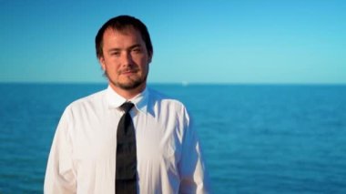Mavi deniz kenarında genç işadamı
