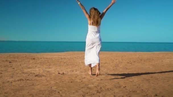 Beyaz elbiseli mutlu kız denize çalışır ve sevinir — Stok video