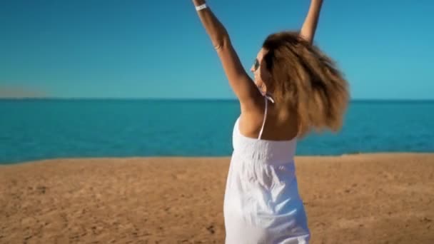 Menina feliz em vestido branco corre para o mar e se alegra — Vídeo de Stock