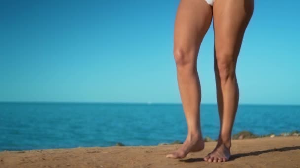 Ženské nohy běží naboso na pobřeží při západu slunce. Nohy mladá žena souvisí ocean Beach během východu slunce.