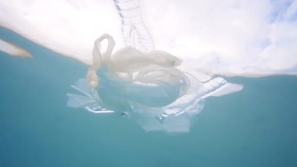 Plastic vervuiling in Oceaan milieuprobleem. Plastic bekers, rietjes, draagtassen en flessen in zee gedumpt — Stockvideo