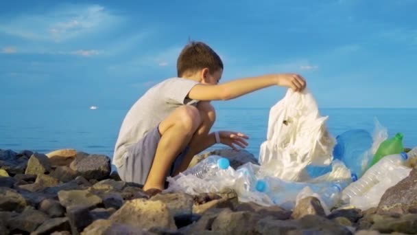 Niño voluntario limpiando la playa en el océano. Concepto de ecología segura . — Vídeos de Stock