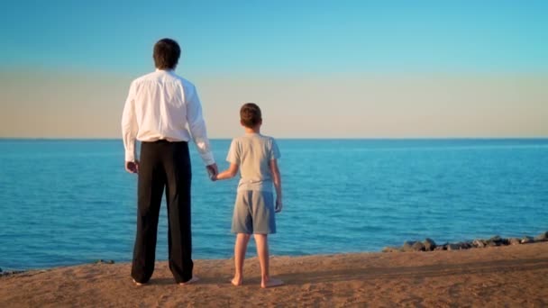 Father with son stand by the hand by the sea — Stock Video