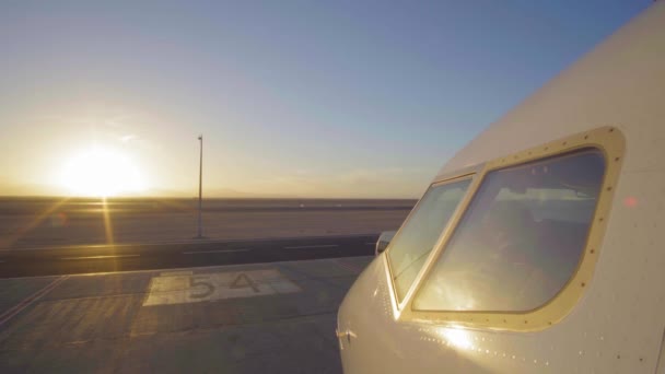 大きな夕日 4 k の前にシルエットとして空港の滑走路でジェット機 Ultrahd — ストック動画