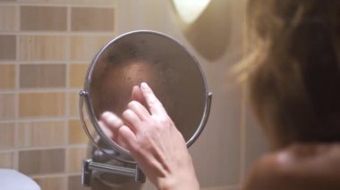 Kız bir parmak kalp banyo aynası çizer.