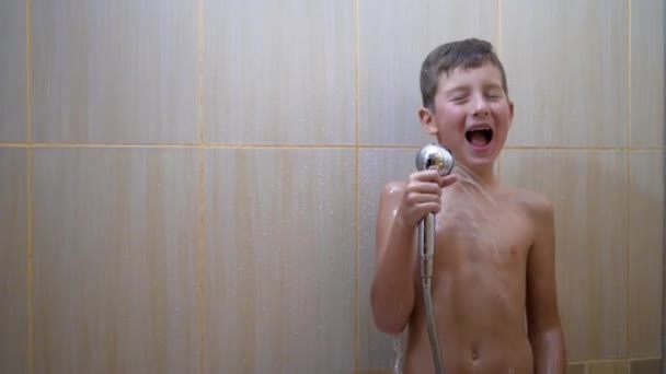 El joven guapo se da una ducha. el tipo lava, canta y baila en la ducha — Vídeo de stock