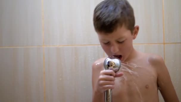 Fiatal jóképű fiú vesz egy zuhany. a fickó mosás, énekel és táncol a zuhany alatt — Stock videók