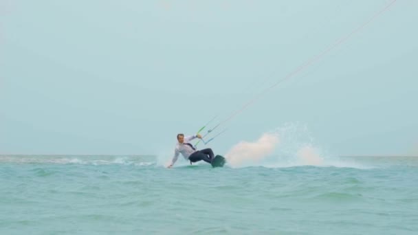 Businessman rides a kite in the tropical ocean and performs tricks Slow motion — Stock Video