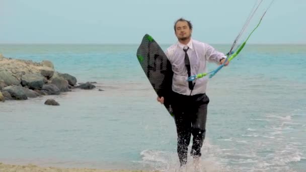 Geschäftsmann fährt Drachen im tropischen Ozean und führt Tricks in Zeitlupe vor — Stockvideo