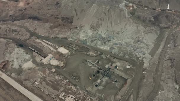 Veduta aerea della cava mineraria a cielo aperto con un sacco di macchinari al lavoro - vista dall'alto. Fossa di scorie — Video Stock